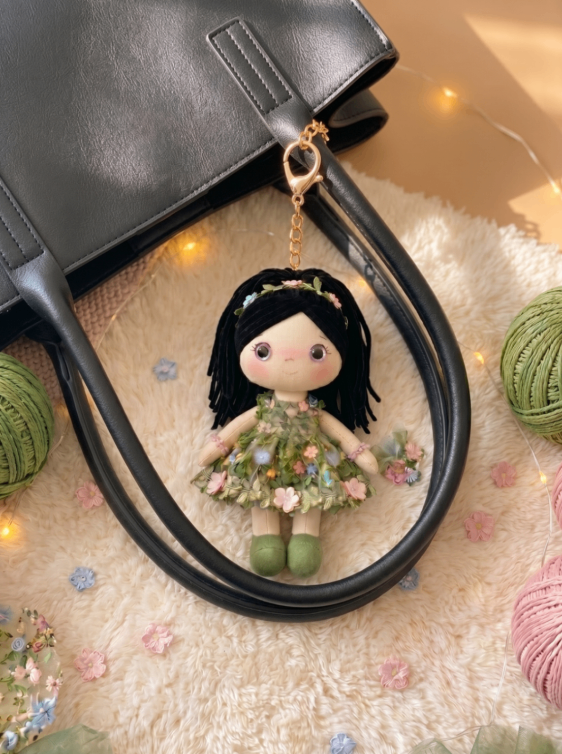 Botanical Garden bag charm with gold hardware on a black leather tote.